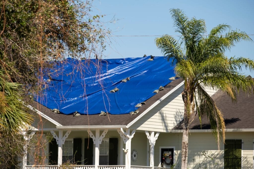 Hurricane-damaged Florida roof covered with a protective tarp