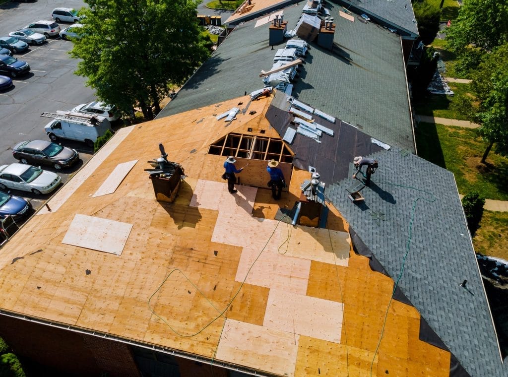 Roofing contractor in Florida installing shingles on residential home roof